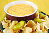 Stock-photo-bowl-of-warm-queso-cheese-dip-with-a-plate-of-tortilla-chips-3144749_medium